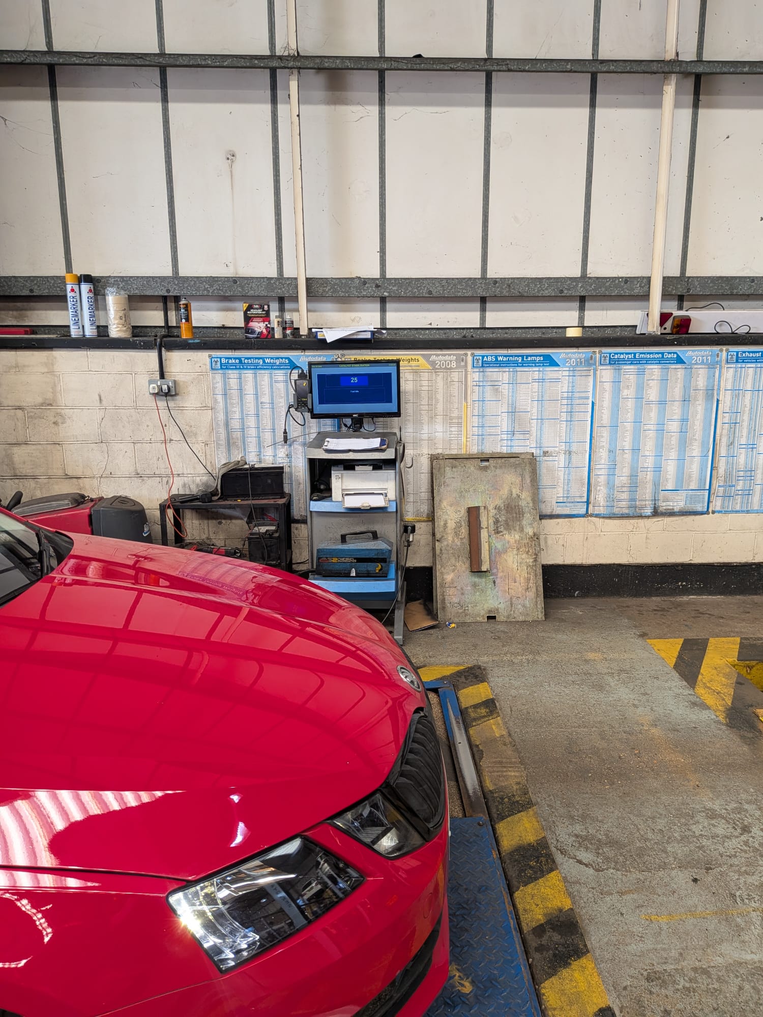 Car at the Best Autocentres MOT testing station with emissions and brake test equipment